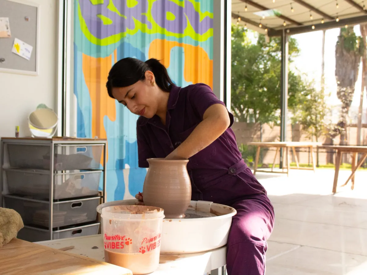 A member centering a vase on the wheel in a members-only wheel throwing class at Annebrije Pottery Studio in Brownsville, TX