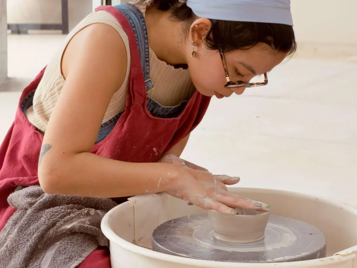 Potter shaping a bowl on the wheel during open studio hours at Annebrije Pottery Studio in Brownsville, TX